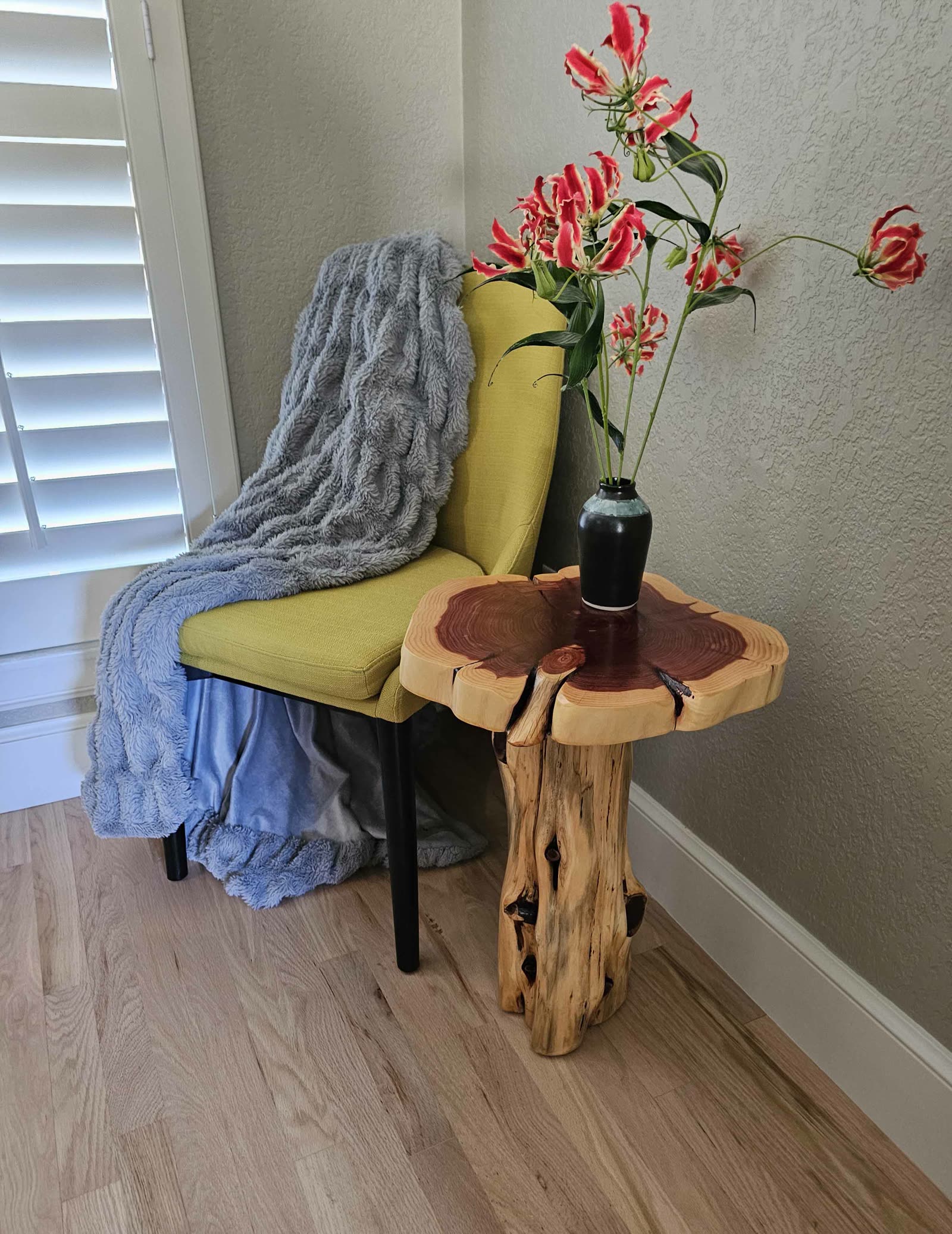 Live-edge cedar stump side table beside a chair