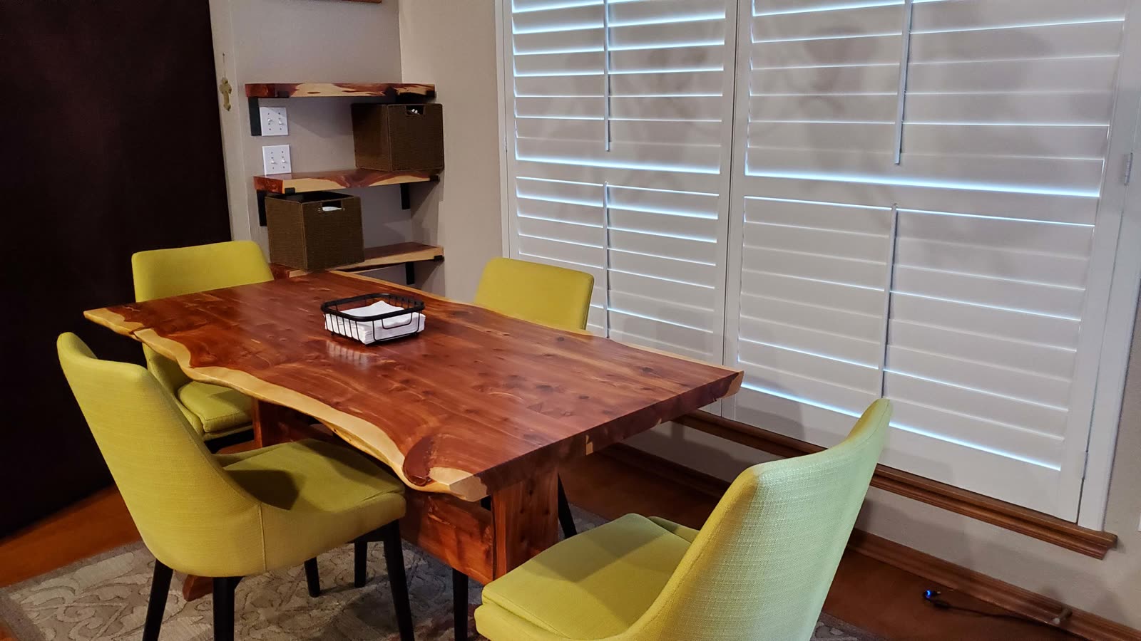 Live-edge cedar trestle table with yellow chairs and matching shelves