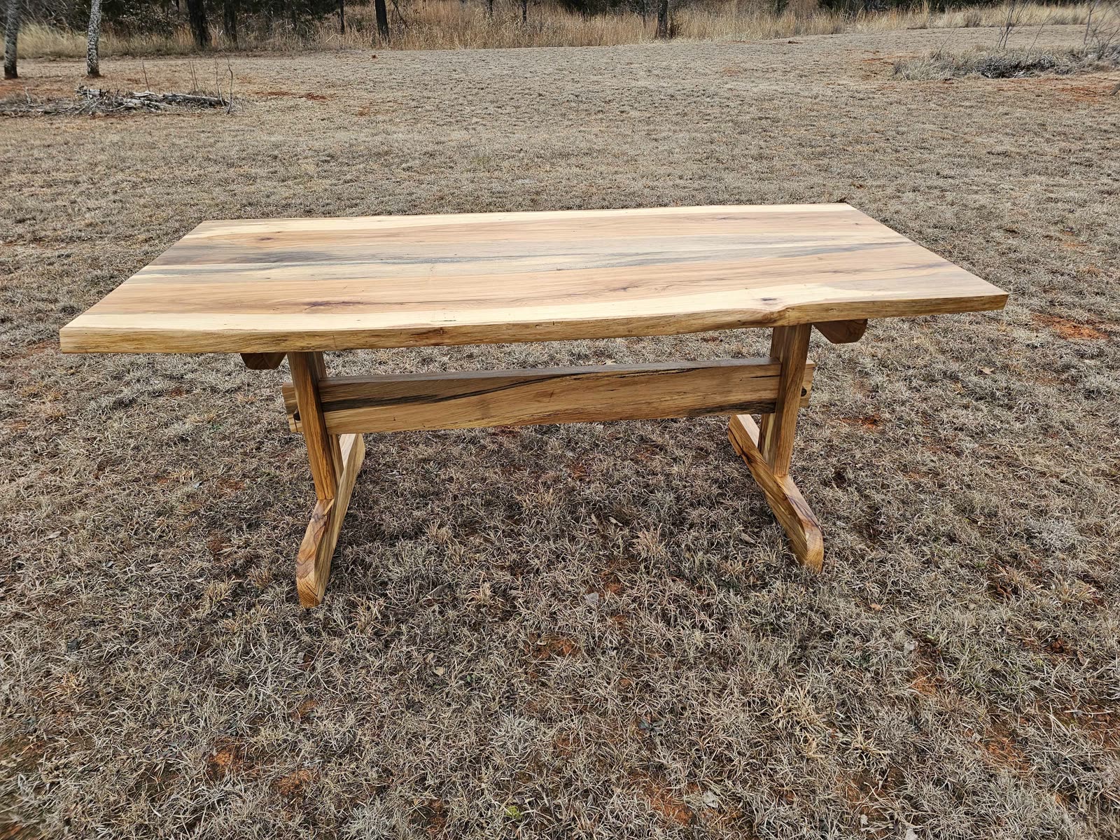 Pecan dining table with a trestle base